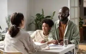 photo of a teacher meeting with a student and parent.